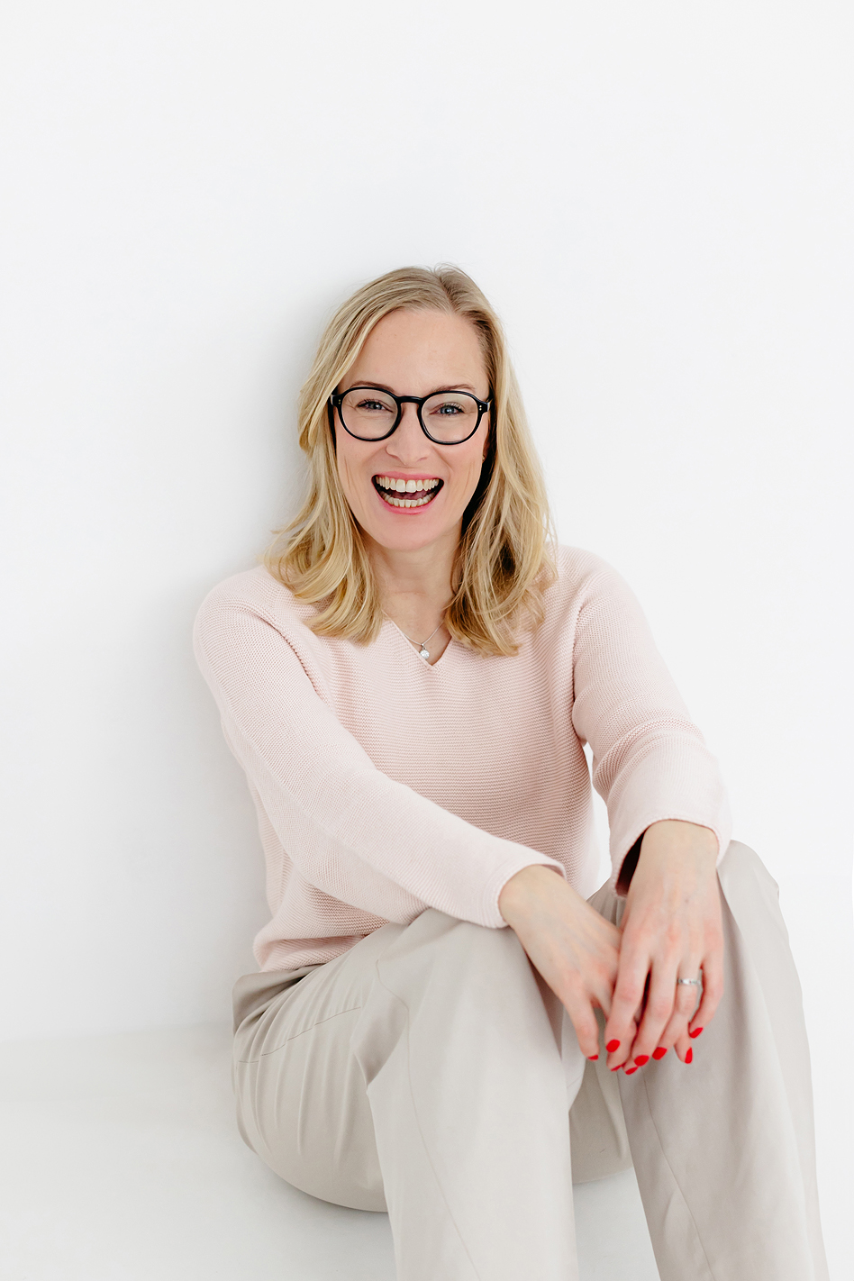 Personal Branding Fotografie einer Unternehmerin mit offenem Lachen und entspannter Sitzhaltung